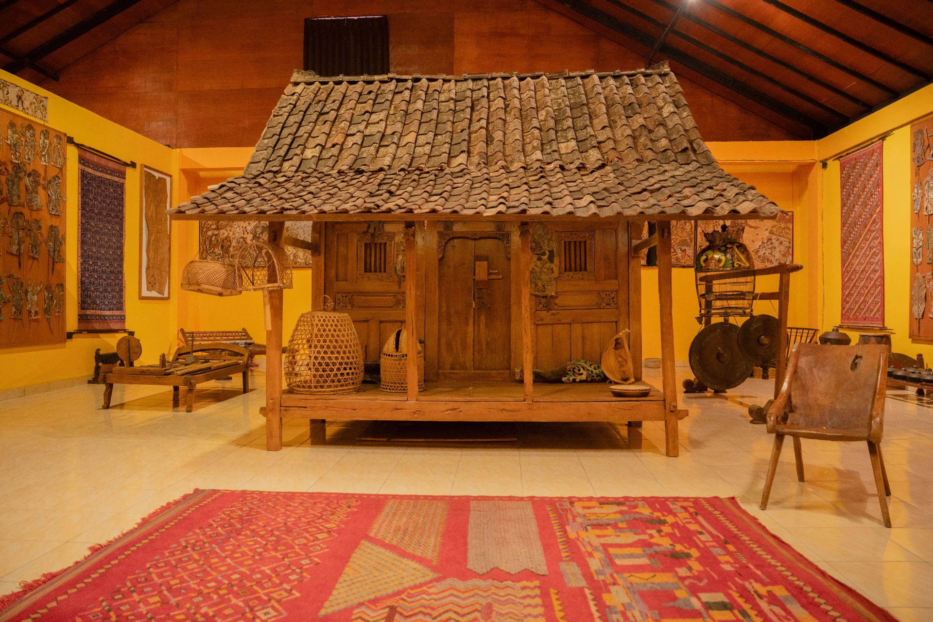 Intricate wood carvings on a traditional Tuban house pillar, featuring authentic Balinese craftsmanship at Museum Peter Bloch Collection.