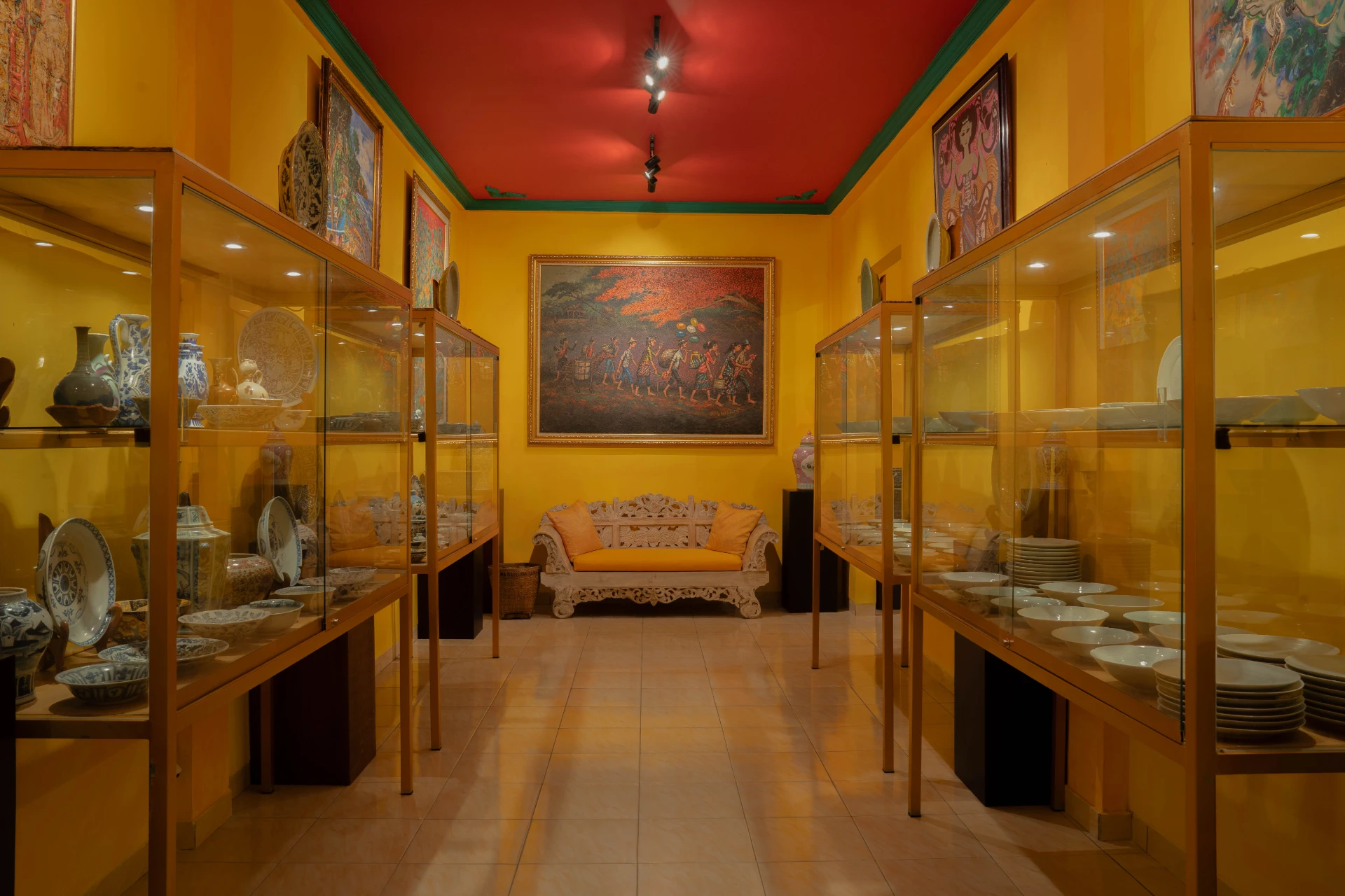 Traditional Chinese ancestor portrait painting displayed on a red wall above a Ming-style altar table, Museum Peter Bloch Collection.